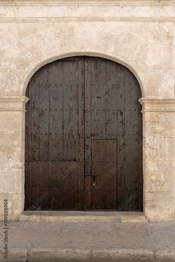 Old thick wooden door in the streets of Cartagena. Colombia