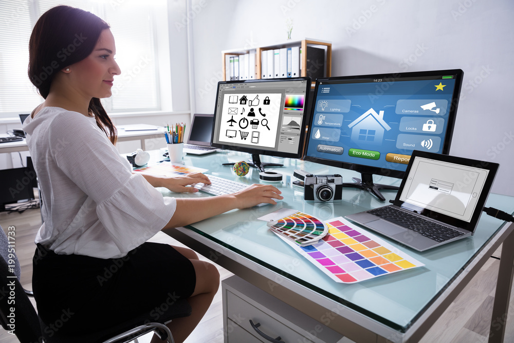 Female Designer Working On Multiple Computer Female Designer Working On Multiple Computer