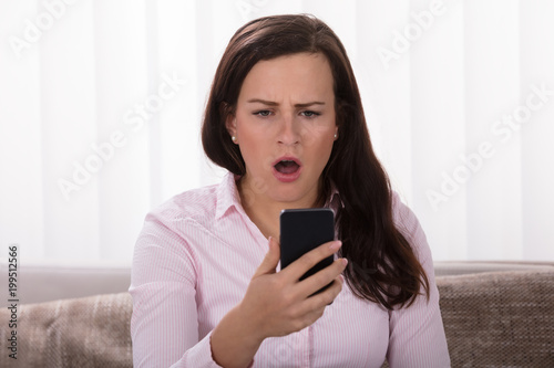 Shocked Woman Looking At Mobile Phone