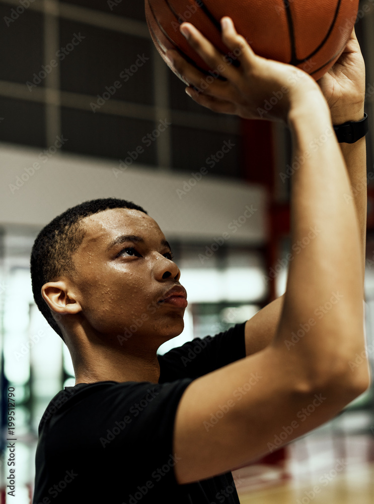 Fototapeta premium African American teenage boy concentrated on playing basketball