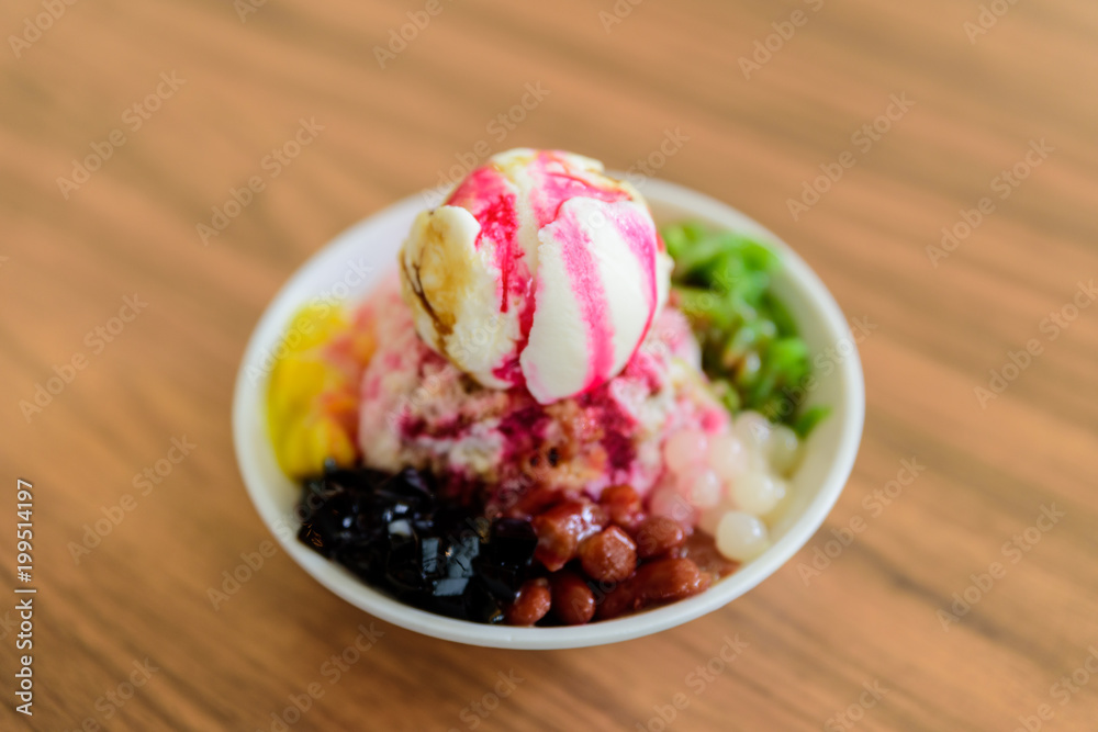 Soft focus of Ais Kacang topped with basil seeds, peanuts, corn, and a scoop of ice cream. Ice