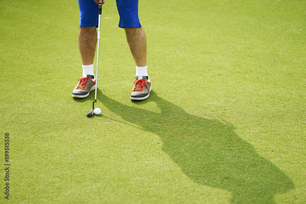 Obraz premium Asian golfer putting on green in summer vacation
