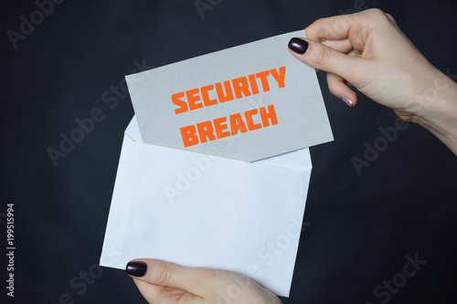 In the hands of a businessman an envelope with the inscription:SECURITY BREACH