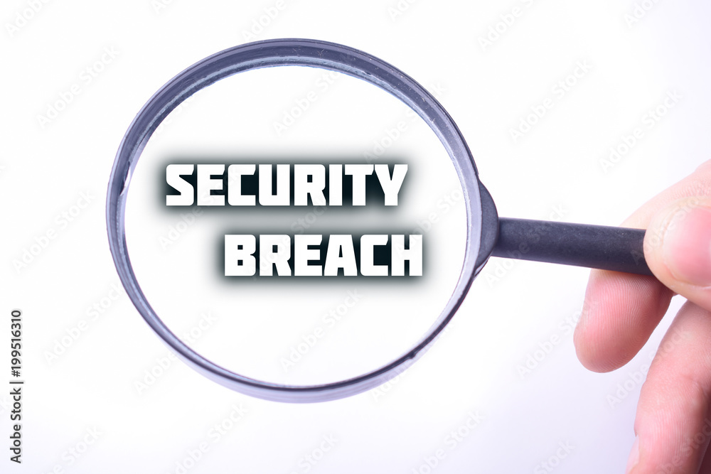 Businessman looking at a magnifying glass word:SECURITY BREACH Businessman looking at a magnifying glass word:SECURITY BREACH