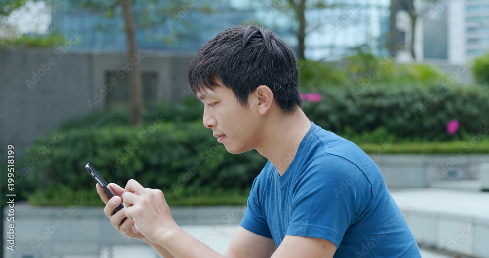 Asian man using cellphone to send sms