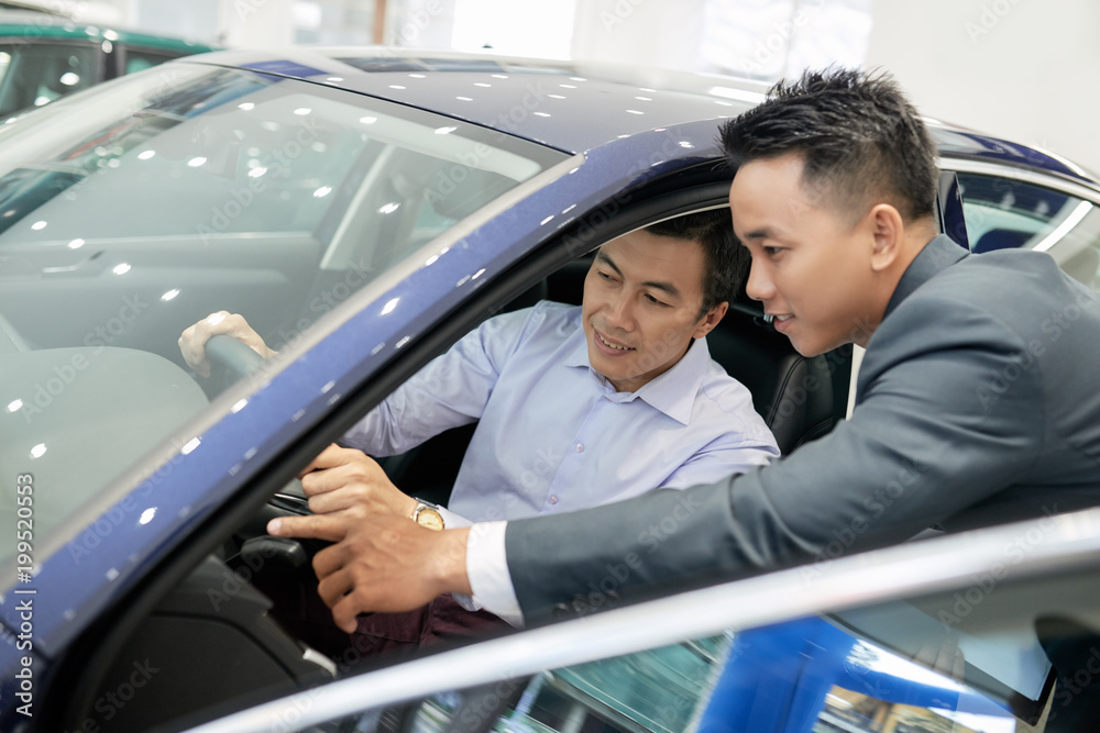 Car seller helping with dashboard Car seller helping with dashboard