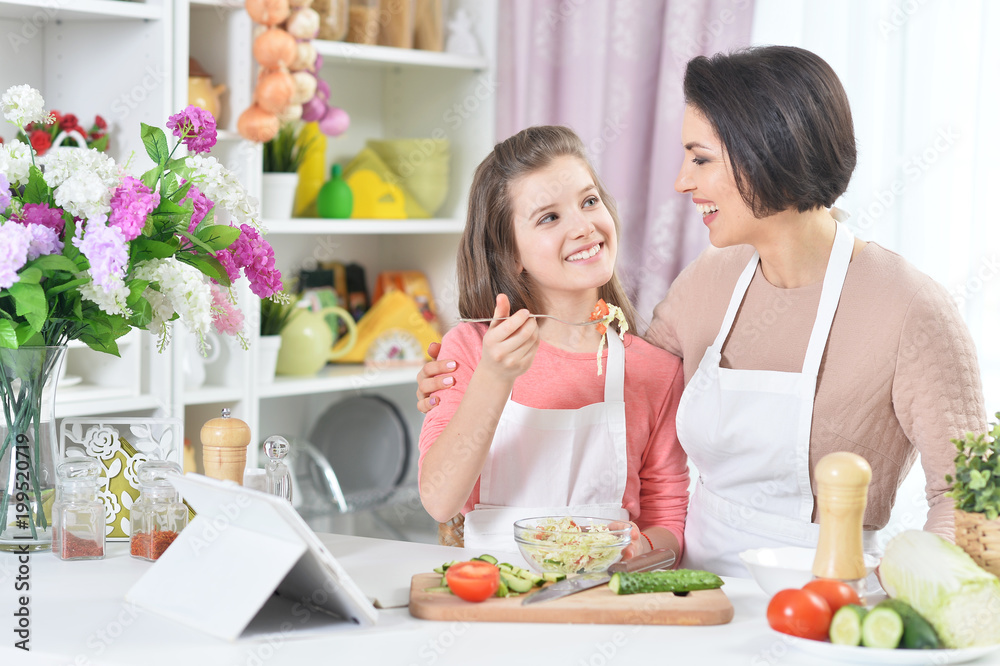 Mother and daughter cooking together at kitchen