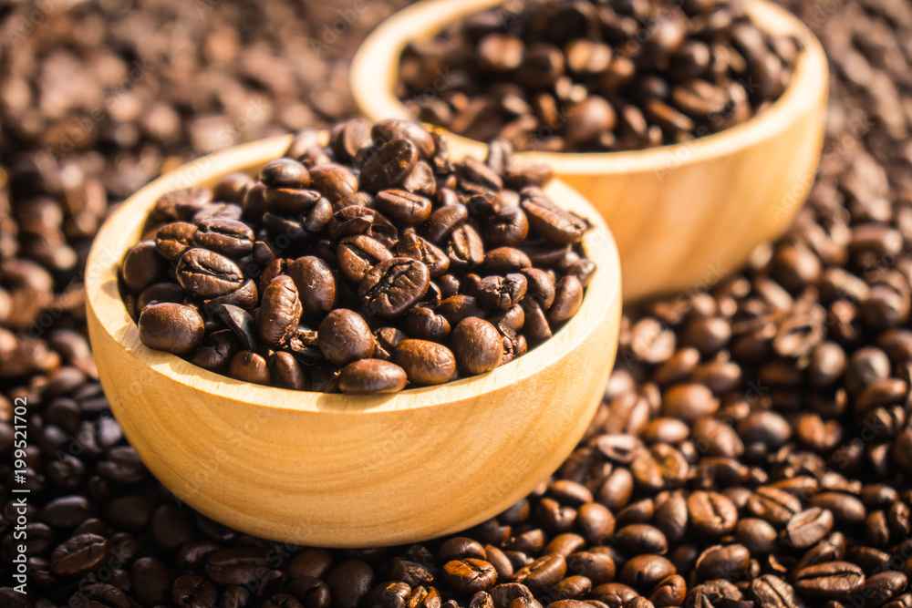 Brown coffee beans in wood bowl Brown coffee beans in wood bowl