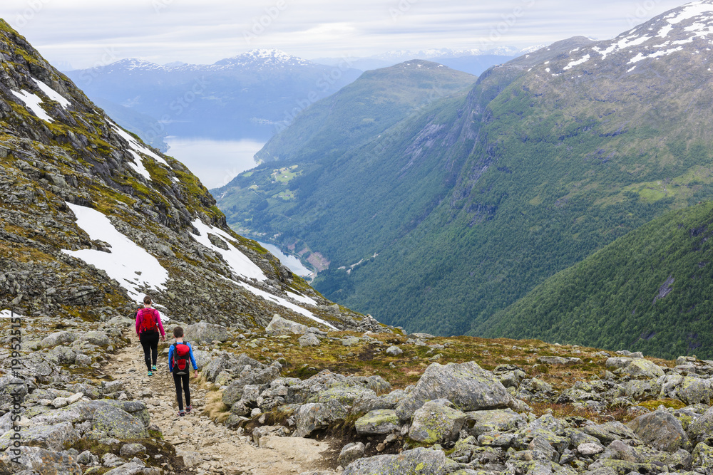 Woman and boy hiking in mountain landscape Woman and boy hiking in mountain landscape