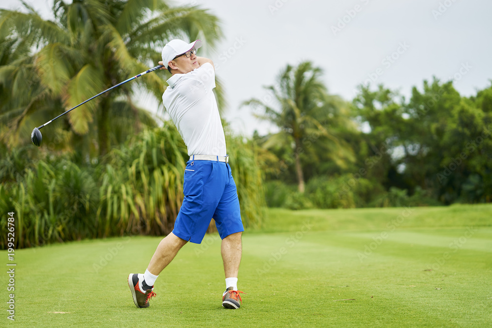 Asian man playing golf swing club for tee-off in course