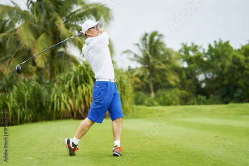 Asian man playing golf swing club for tee-off in course © allensima