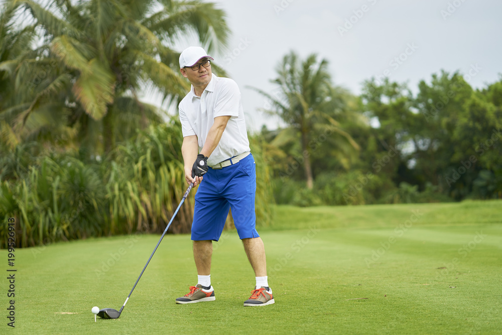 Fototapeta premium Asian man playing golf swing club for tee-off in course