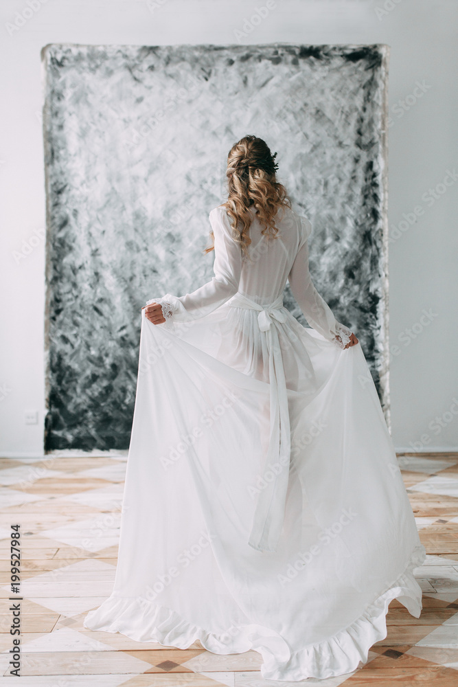 Beautiful young bride in boudoir dress on canvas background with paint. Wedding trends and ideas 2018, spring inspiration. Wedding in the Studio