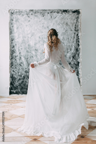Beautiful young bride in boudoir dress on canvas background with paint. Wedding trends and ideas 2018  spring inspiration. Wedding in the Studio