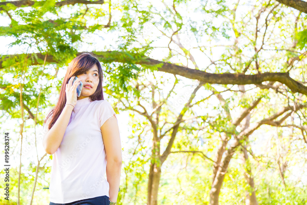 Beautiful women talking on cellphone in park Beautiful women talking on cellphone in park