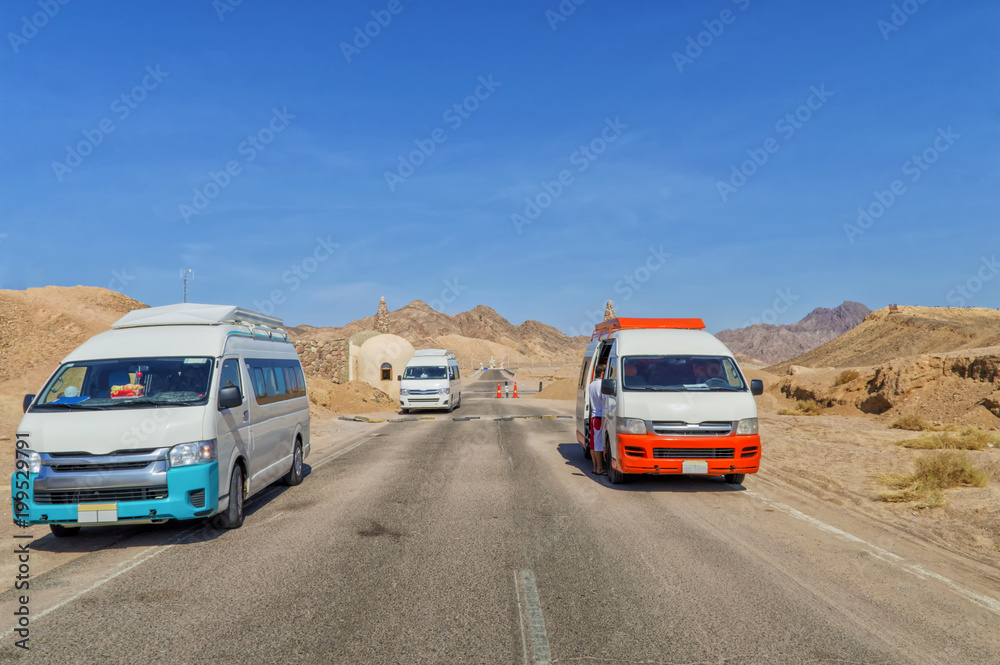 entrance to Ras Mohamed National Park in Egypt, asphalt road, desert landscape, minibuses, buildings, against a blue sky without a cloudy sky