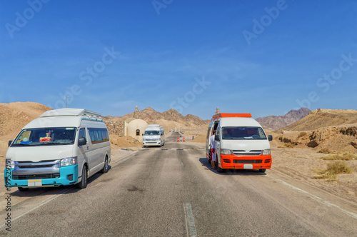 entrance to Ras Mohamed National Park in Egypt, asphalt road, desert landscape, minibuses, buildings, against a blue sky without a cloudy sky