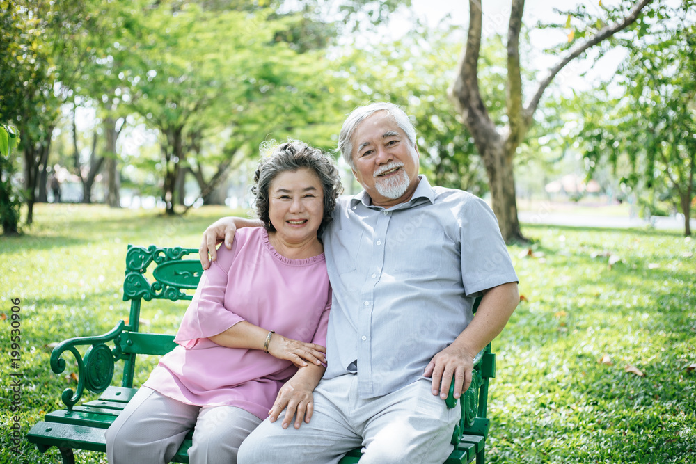 healthy senior couple relaxing seats on Chair in the park healthy senior couple relaxing seats on Chair in the park