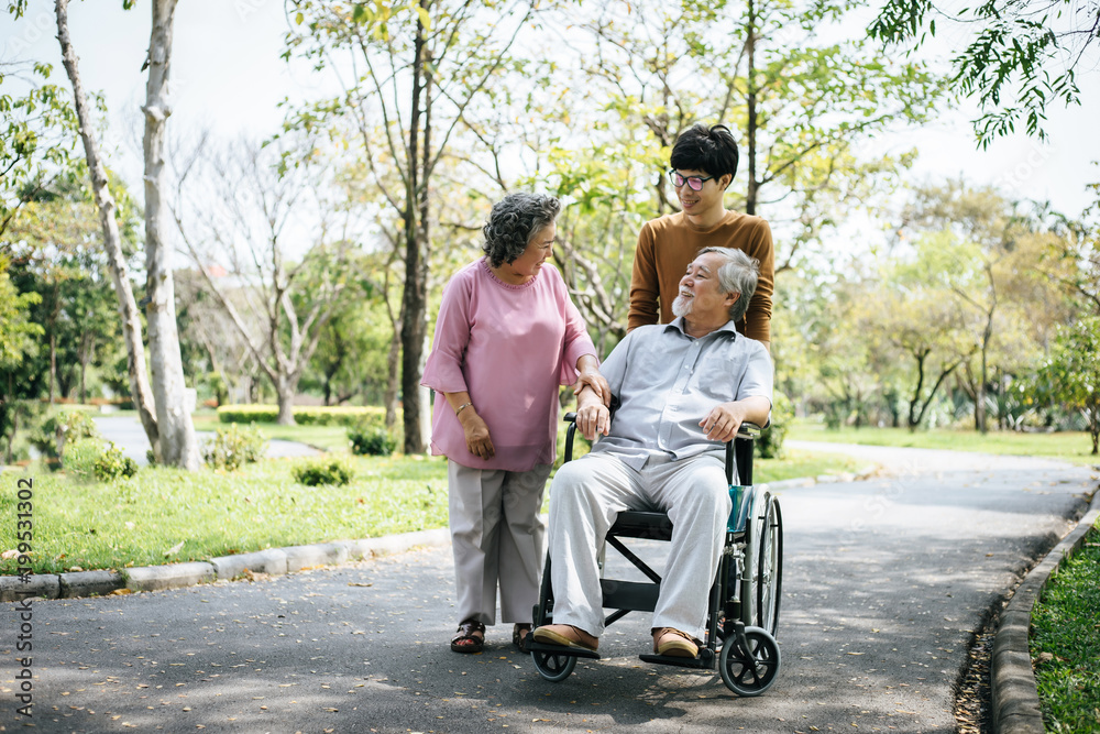 cheerful disabled grandfather in wheelchair welcoming his happy Family cheerful disabled grandfather in wheelchair welcoming his happy Family