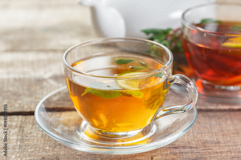 cup of black tea with mint leaves on a wooden table cup of black tea with mint leaves on a wooden table