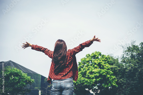Successful sporty woman raising arms towards on the sky Background