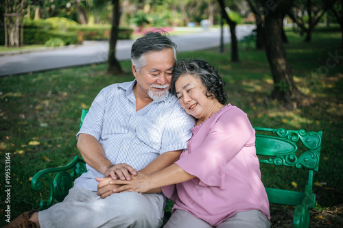 healthy senior couple relaxing  seats on Chair in the park © Johnstocker