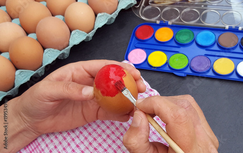 Hand painting easter eggs with red paint
