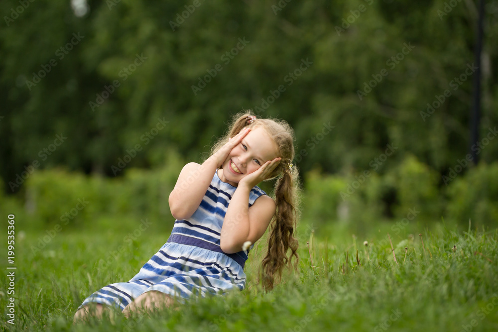 Smiling child girl wearing blue summer dress is playing in park Smiling child girl wearing blue summer dress is playing in park