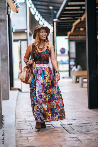 The woman is walking on the street with great smile.