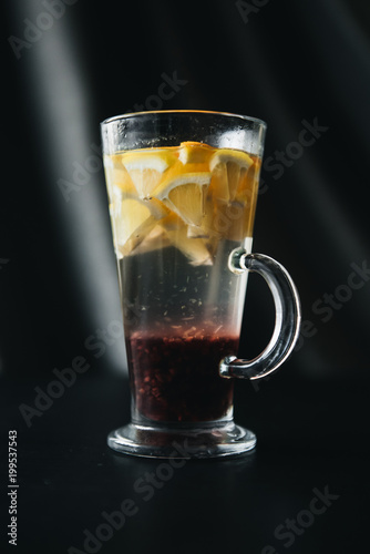 Traditional winter and autumn drinks. Christmas and Thanksgiving Cocktails. Mulled wine with orange, apple, rosemary, cinnamon and spices on a dark stone background, copy space top view