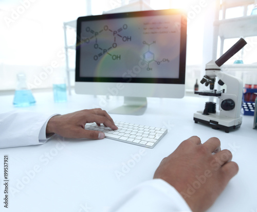 A scientist uses a computer and a microscope