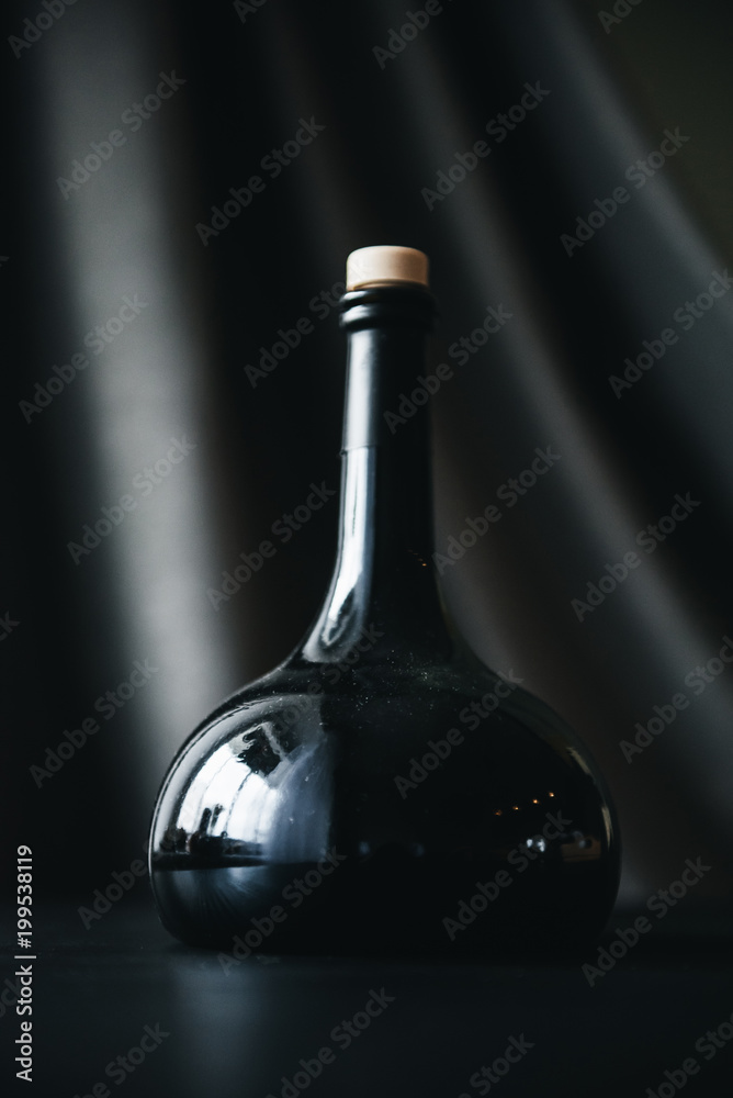 Bottle of red wine on grey wooden background