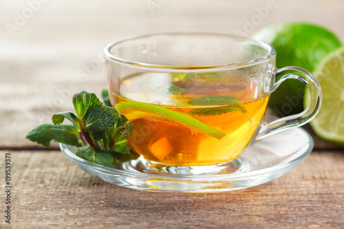 cup of black tea with mint leaves on a wooden table
