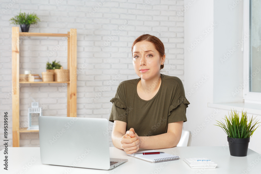 Portrait of a happy casual businesswoman sitting at her workplace in office Portrait of a happy casual businesswoman sitting at her workplace in office