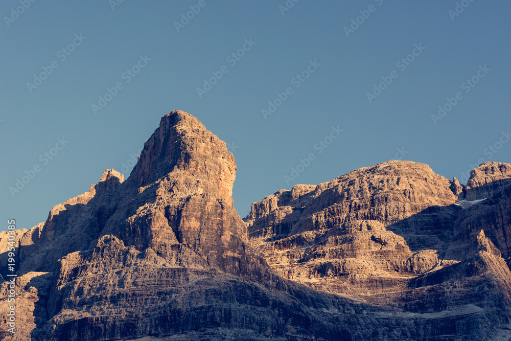 Sun illuminated mountain peaks.