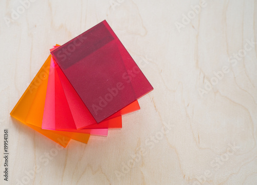 Colorful pieces of plexiglass on a wooden background.
