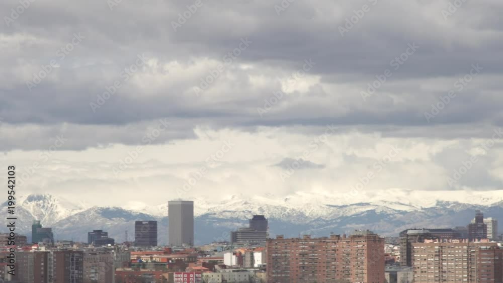 Panoramic view to Madrid, the skyscrapers and television tower El Pirul. Cityscape, cloudy day over Madrid, background snowy mountain Panoramic view to Madrid, the skyscrapers and television tower El Pirul. Cityscape, cloudy day over Madrid, background snowy mountain
