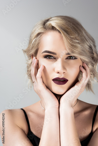 portrait of attractive blonde girl with makeup, isolated on grey