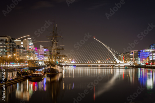 Beautiful night view of Dublin with water, bridge and buildings.