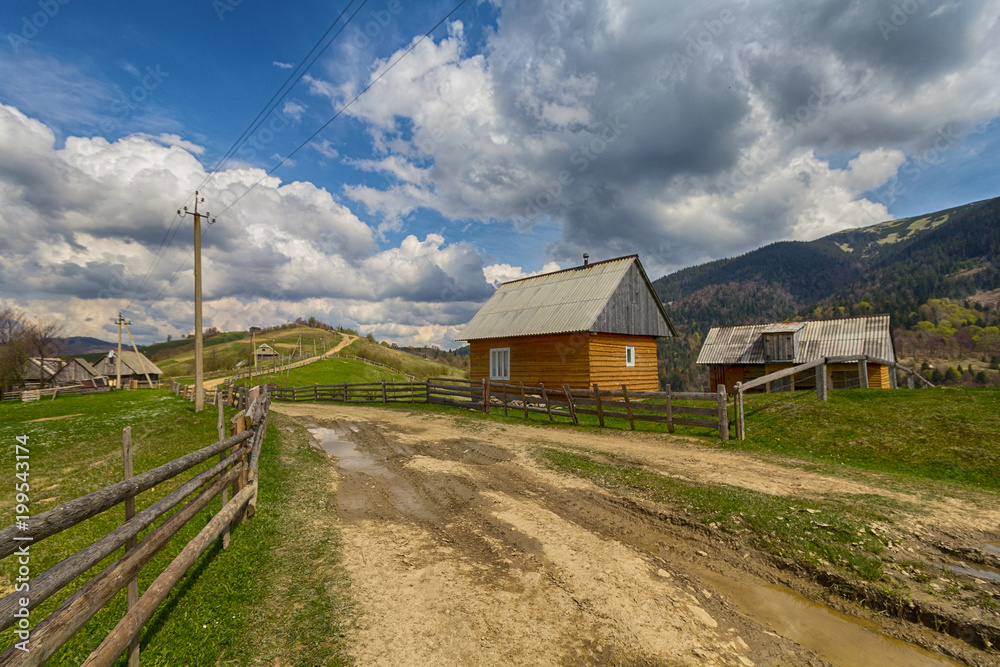 Road and a fence in a mountain village. Carpathians, Ukraine