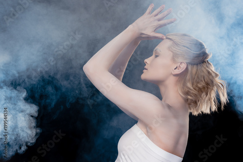 side view of attractive blonde girl in smoky studio
