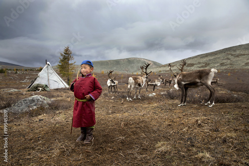 tsaatan kid next to his family home in a taiga of northern Mongolia  photo