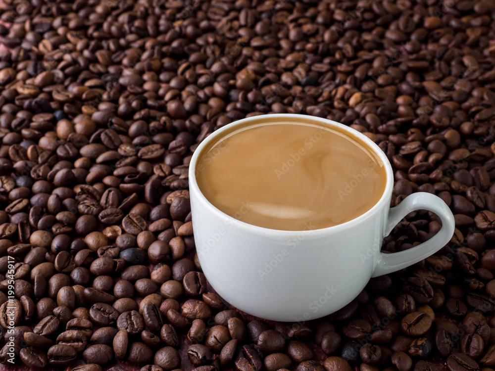 Cup of coffee with milk on background of coffee beans Cup of coffee with milk on background of coffee beans
