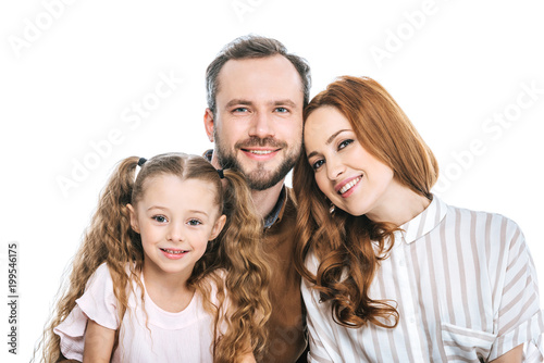 happy parents with adorable little daughter smiling at camera isolated on white