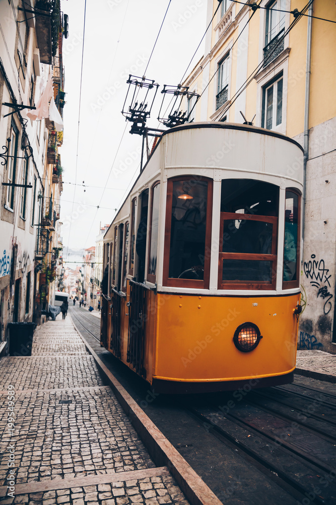 Classic tram with graffiti on old street, Lisbon, Portugal