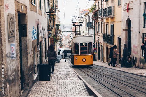 Classic tram with graffiti on old street, Lisbon, Portugal