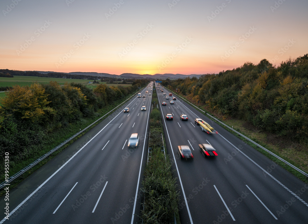 Naklejka premium The road traffic on a motorway at sunset