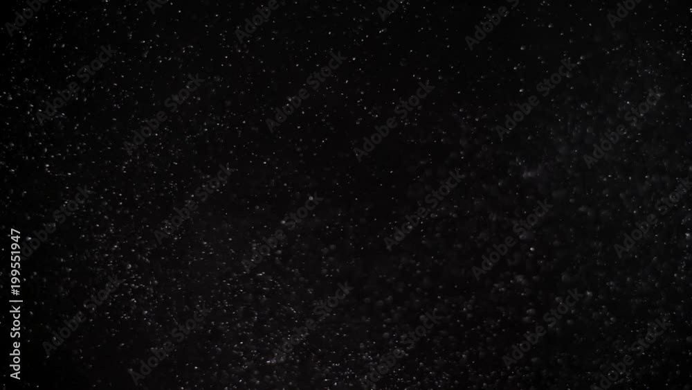 Slow moving real dust particles on black background.