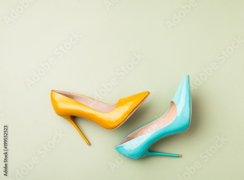 Set of colored women's shoes on green background