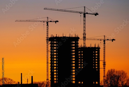 Construction of high-rise buildings against the background of sunset.